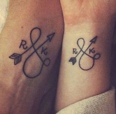 two people with matching tattoos on their wrists, one is holding the other's hand