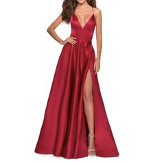 La Femme Stappy Back Satin Ballgown. Deep Red, V-Neck, A-Line, Leg Slit. Liquid Shimmer Pours Down This Satin Ballgown Cut With No Small Measure Of Daring Via A Plunging Neckline, An Open, Strappy Back And An Unexpected Front Slit. 60" Length Ties In Back Plunging V-Neck Sleeveless Full-Length Ball Skirt With Front Thigh-High Slit Get The Perfect Fitbook An Appointment With One Of Our Alterations Experts Lined 100% Polyester Spot Clean Imported Special Occasion Item #5961580 Size: 6 Condition: N Red Prom Dress Ball Gown, Red Formal Gown, Dress Couture, Prom Dress Stores, Prom Dress Styles, Sleeveless Gown, Prom Style, Prom Designs, Designer Prom Dresses