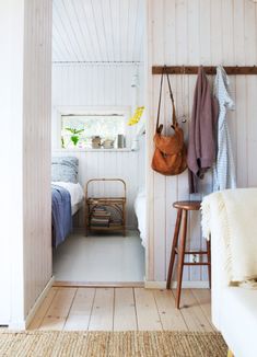 a bedroom with white walls and wooden floors