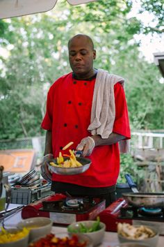 a man standing in front of a table with food on it and holding a plate