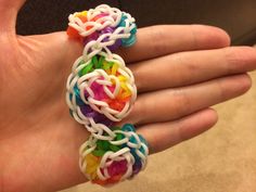 a hand holding a multicolored ring made out of plastic beads