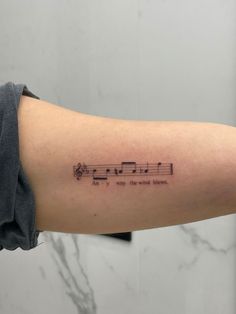 a person's arm with musical notes on it