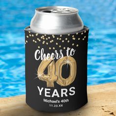 a can cooler with cheers to 40 years on it next to a swimming pool ornament