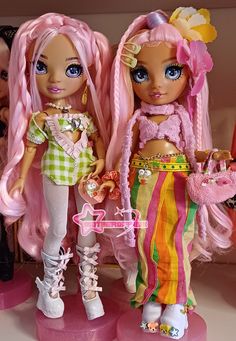 two dolls standing next to each other in front of a shelf filled with doll accessories