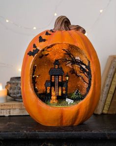 a carved pumpkin with a house inside it