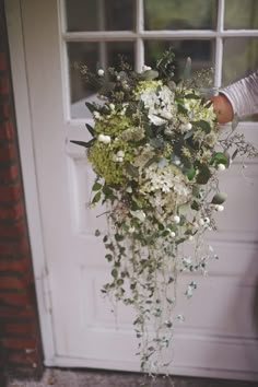 a person holding a bouquet of flowers in front of a door