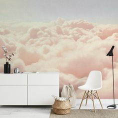 a living room with a large wall mural and white furniture in front of the clouds