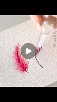 someone is painting a red feather on paper