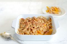 a casserole dish with peaches and crumbled toppings