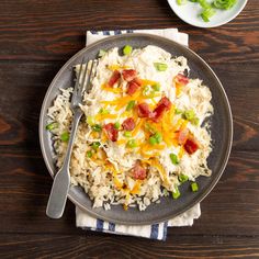 a plate with rice, bacon and green onions on it