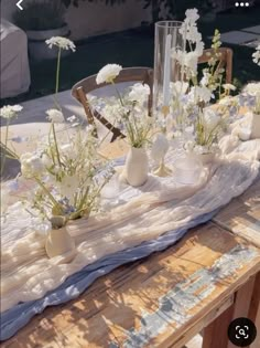 a table topped with vases filled with white flowers