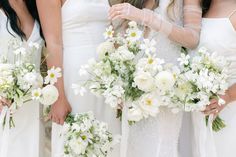 the bridesmaids are holding bouquets of white flowers and greenery in their hands