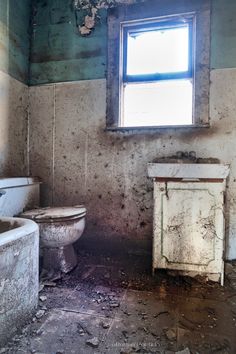 an old run down bathroom with peeling paint on the walls and floor, including a toilet and sink