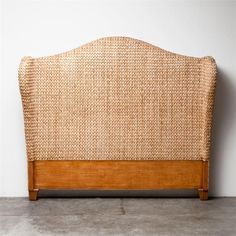 the headboard is made out of wood and wicker with an upholstered design