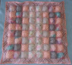 a quilted square with many different colored balls on it's sides and the center is made out of fabric