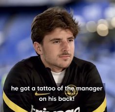 a man sitting down with a quote on his shirt that says he got a tattoo of the manager on his back