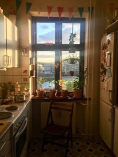 a kitchen with a window, sink and stove top oven sitting next to a refrigerator