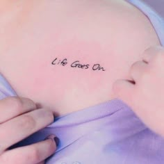 a woman's stomach with the words life goes on written in cursive font