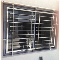 a person standing in front of a window with bars on it