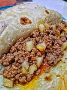 two burritos on a plate with meat and onions in them, ready to be eaten