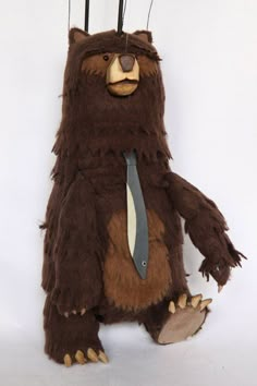 a stuffed bear wearing a tie and standing on its hind legs with needles stuck to it's head