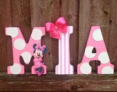 a pink and white wooden letter with minnie mouse on it's lower letters that spell out the word mia