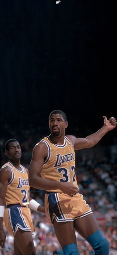 two basketball players standing on the court with their hands in the air and one has his arm out