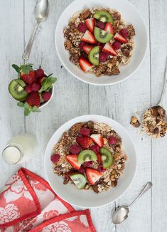 two white plates topped with granola and fruit