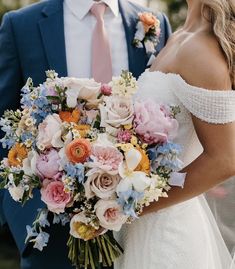 a bride and groom holding a bouquet of flowers