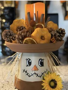 a pumpkin decoration with pine cones and sunflowers