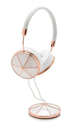 a pair of headphones on a stand with white and pink wire, against a white background