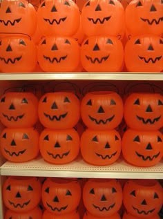 a shelf filled with lots of orange pumpkins