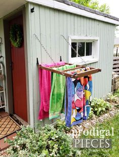 colorful towels hanging on clothes line in front of shed