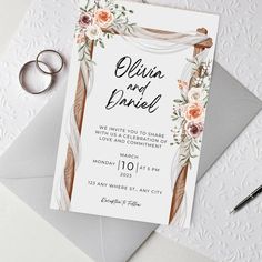 an image of wedding stationery with flowers and rings on top of the stationery