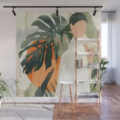 a large tropical painting on the wall next to a chair and book shelf in front of a bookshelf