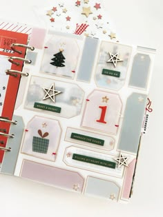 an open planner book with christmas stickers on the pages and other items in it