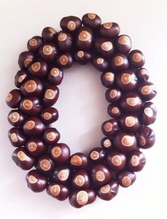 a close up of a wreath made out of brown beads on a white surface with holes in the middle