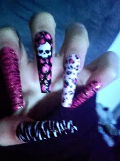 a person with pink and black nail art on their fingers, holding a fake skeleton