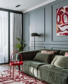 a living room filled with furniture and a painting on the wall