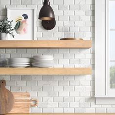 a kitchen with white brick walls and wooden shelves