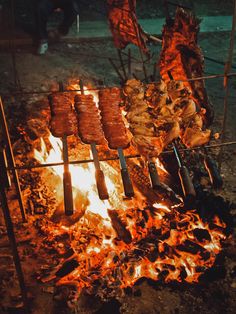 hot dogs and sausages cooking over an open fire