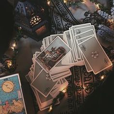 the tarot cards have been placed on top of each other with fairy lights around them