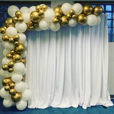 a white and gold balloon arch with balloons