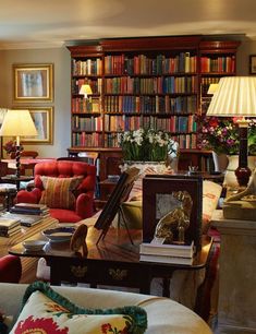 a living room filled with lots of furniture and bookshelves covered in bookcases