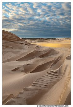 sand dunes with clouds in the sky