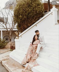 a man and woman are sitting on the stairs