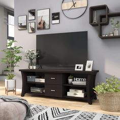 a flat screen tv sitting on top of a wooden entertainment center in a living room