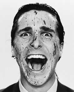 a man in a suit and tie has his mouth open with paint all over his face