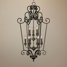 a chandelier with five lights hanging from it's center point in a room