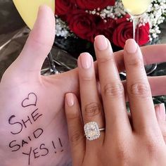 two people holding each other's hands with the words she said yes written on their fingers